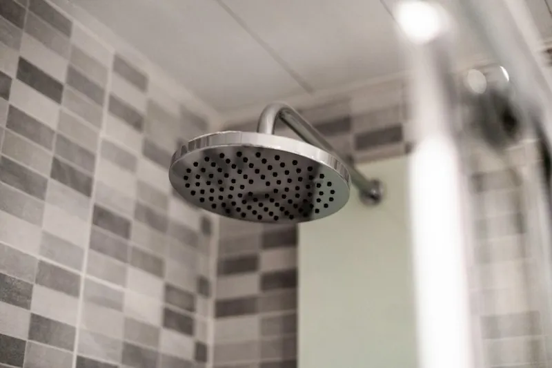 Ducha de acero instalada en un baño con cerámica