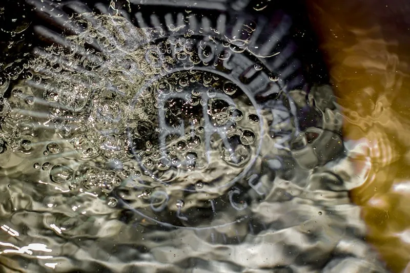 Agua acumulada sobre una rejilla de desagüe